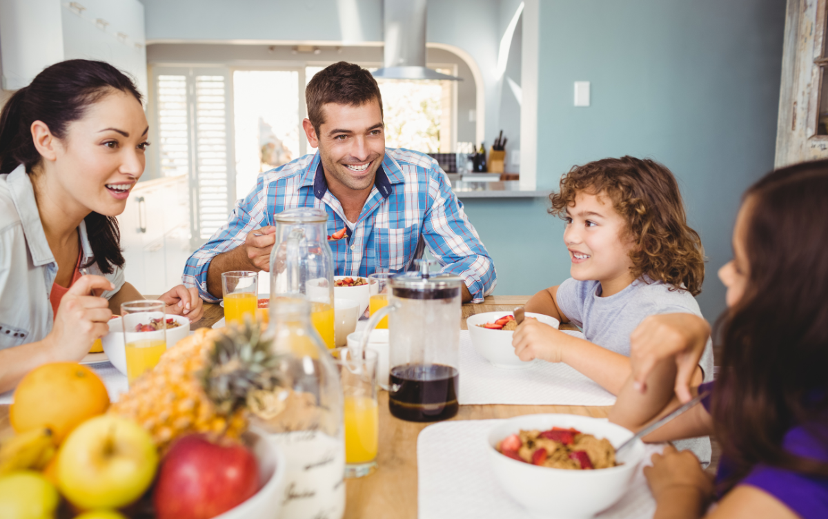 A cheerful family at breakfast, with colorful fruits and cereals